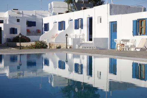 uma piscina de água em frente a edifícios brancos em Nikos Rooms em Vrisi/ Míconos