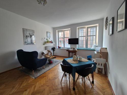 a living room with a blue table and chairs at Apartment in Old Town - view of Mariacki Church in Gdańsk