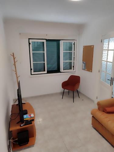 a living room with a guitar and a chair at Casa da Silveira in Angra do Heroísmo