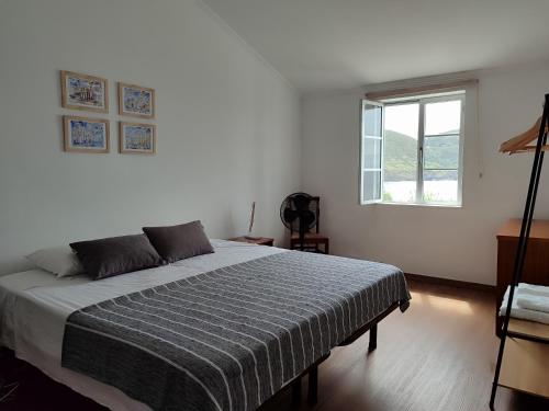 a bedroom with a bed and a window at Casa da Silveira in Angra do Heroísmo