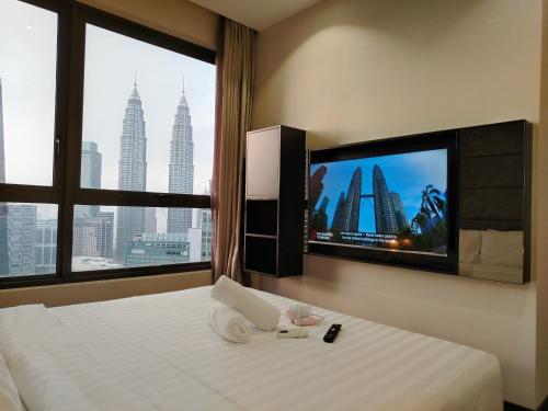 a hotel room with a bed and a large window at KLcc suites by BHS in Kuala Lumpur