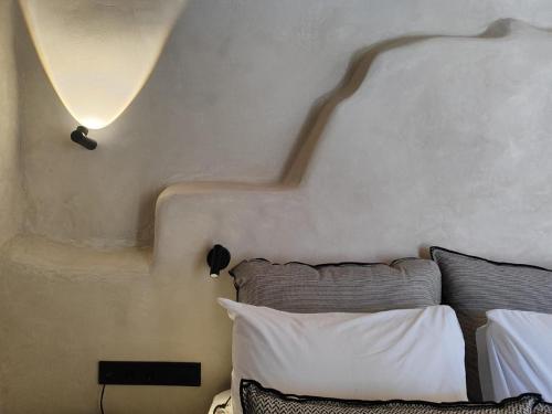 a bedroom with a bed with a shadow on the wall at Ruga of Vamvakou Homes in Vamvakoú