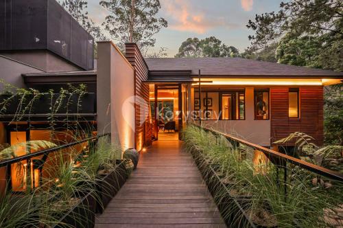 a house with a wooden walkway leading to it at Taman Wisata Bougenville by Kozystay in Malabar