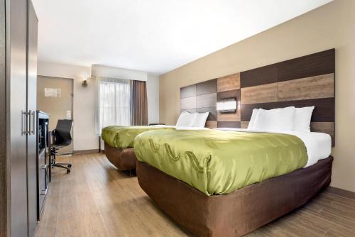 a hotel room with two beds and a desk at Quality Inn Panama City North in Panama City