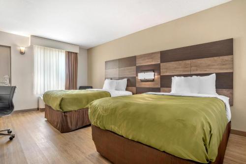 a hotel room with two beds and a chair at Quality Inn Panama City North in Panama City