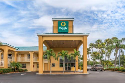 a front view of a quality hotel with palm trees at Quality Inn Bradenton North I-75 in Bradenton