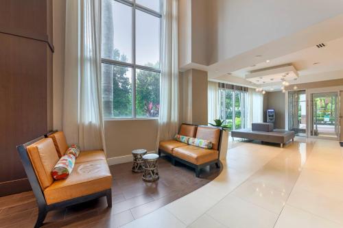 a living room with two chairs and a couch at Comfort Suites Miami Airport North in Miami