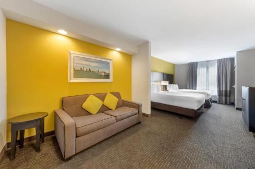 a hotel room with a couch and a bed at Comfort Suites Miami Airport North in Miami