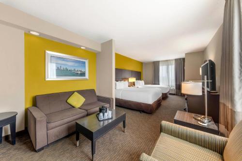 a hotel room with a bed and a couch at Comfort Suites Miami Airport North in Miami