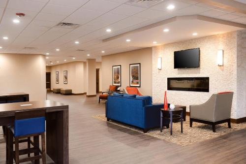 a waiting room with a blue couch and a tv at Comfort Inn & Suites Event Center in Des Moines