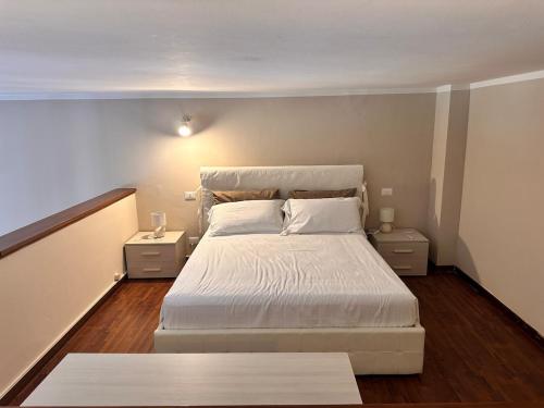 a bedroom with a white bed and two night stands at glamour home arezzo in Arezzo