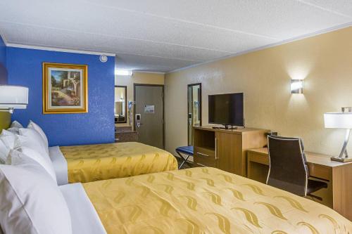 a hotel room with two beds and a television at Quality Inn & Suites near Six Flags East in Atlanta