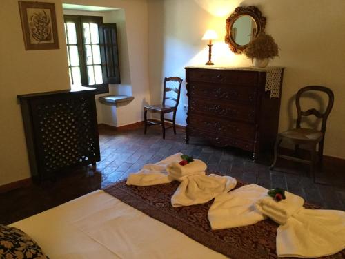 a bedroom with towels on a bed with a dresser at Mas Pardas in Santa Pau