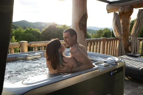 Un hombre y una mujer sentados en un jacuzzi en Holiday Home Ernest Železni with hot tub, en Ivančna Gorica