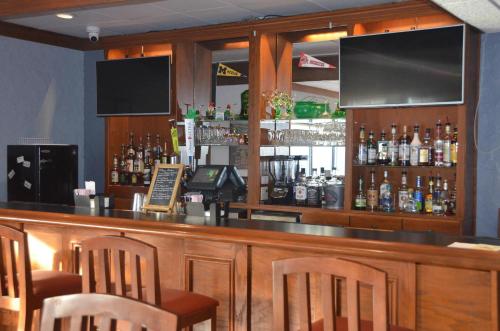 a bar with chairs and a counter with alcohol at Quality Inn in Perrysburg
