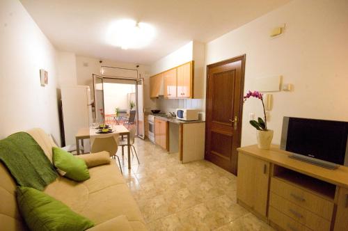 a living room with a couch and a kitchen at Apartments Figueres in Figueres