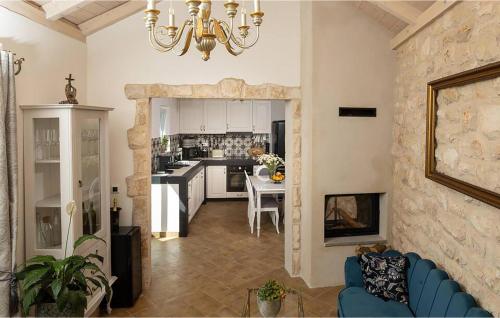 Una sala de estar con un sofá azul y una cocina. en 3 Bedroom Stunning Home In Zarace, en Zarače