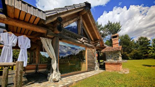 Una cabaña de madera con una gran ventana y una chimenea. en Holiday Home Ernest Železni with hot tub, en Ivančna Gorica