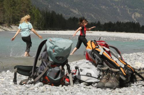 two women walking along a river with a pile of backpacks at Apart-Alpin in Stanzach