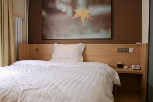 a bedroom with a white bed with a star above it at 7 Days Inn Zhangjiakou Chongli Yuxing Road in Zhangjiakou