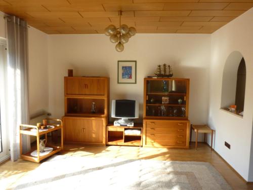 a living room with a tv and a desk with a computer at Wotan in Düsseldorf