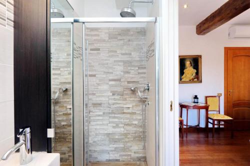 a shower in a bathroom with a stone wall at Terrazze Navona in Rome