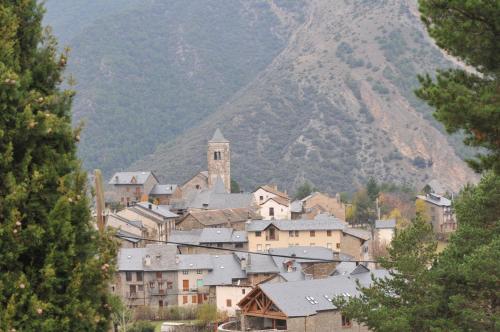 a town in front of a mountain with a church at Casa Rural La Comella in Tirvia