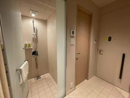 a bathroom with a shower and a glass door at toggle hotel suidobashi TOKYO in Tokyo