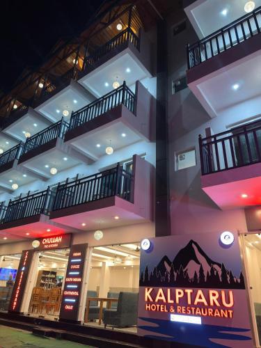 a building with balconies and a sign in front of it at Kalptaru The Kumaon Retreat in Bhowāli