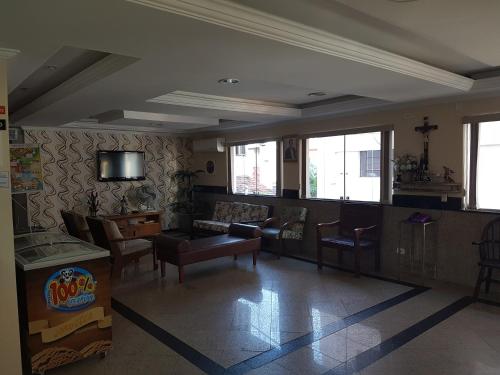 a living room with a couch and a tv at Hotel Colorado in Aparecida