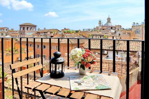 a table with a vase of flowers on a balcony at Terrazze Navona in Rome