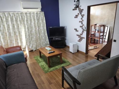 a living room with a couch and a table at 貸切ゲストハウス スポパー徒歩10分 Guesthouse near sports park in Naruto