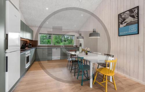 a kitchen with a table and chairs in a kitchen at Nice Home In Oksbøl With Wifi in Øster Vrøgum