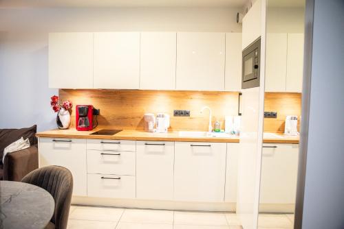 a kitchen with white cabinets and a red appliance at Apartamenty Belni Hel Edyta i Maciej Wolak in Hel