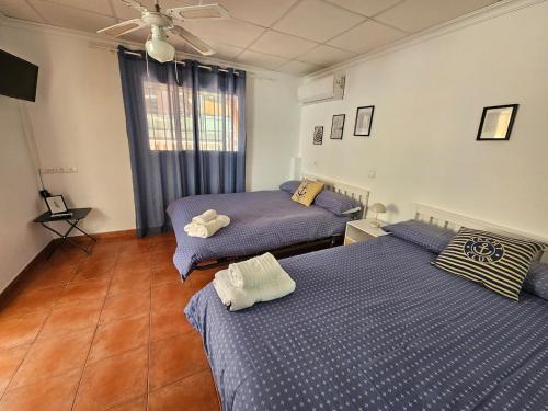 2 camas en un dormitorio con edredón azul en La Maison du Port, en Puerto Sagunto