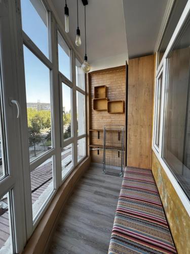 un couloir avec de grandes fenêtres et un tapis dans l'établissement Style apartment Bishkek, à Bishkek
