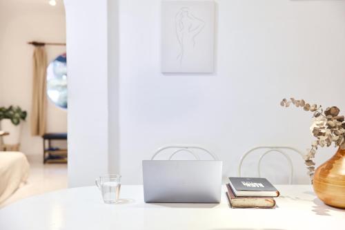 a white table with a laptop and a vase at Saigon Hideout New World View in Ho Chi Minh City