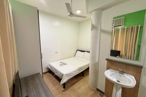 a small room with a bed and a sink at Casa Lily Quezon City in Quezon City