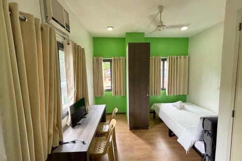 a room with two beds and green walls at Casa Lily Quezon City in Quezon City