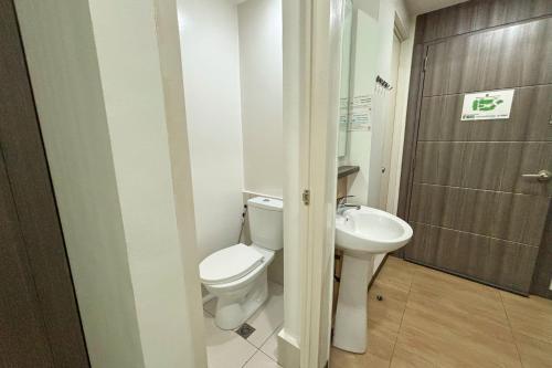 a bathroom with a toilet and a sink at Casa Lily Quezon City in Quezon City