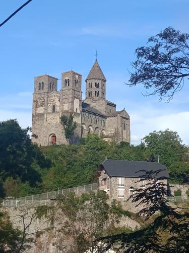 a castle sitting on top of a hill at L'Echappée Romane in Saint-Nectaire