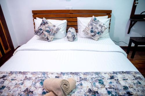 a white bed with pillows and a blanket on it at Cara Galle Fort in Galle