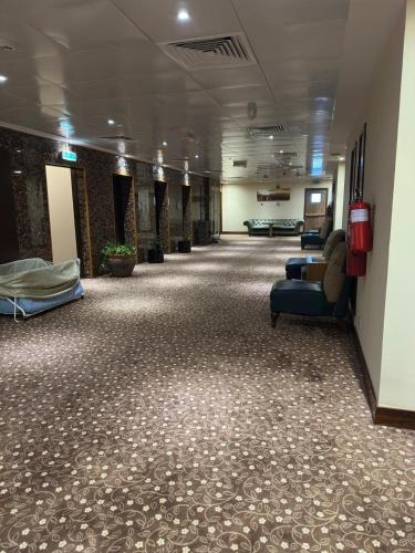 a long hallway of a hospital with couches and chairs at Al Khaleej Palace Deira Hotel in Dubai