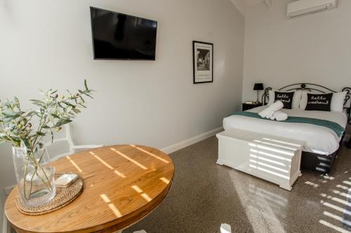 a small bedroom with a table and a bed at Chez Vous Villas Pokolbin in Pokolbin