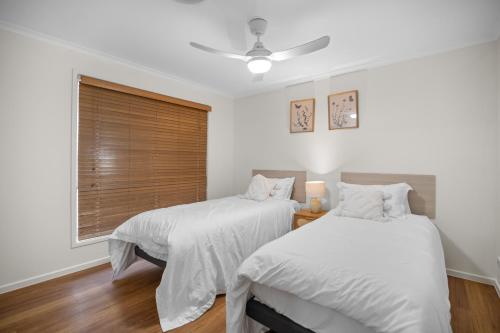 een slaapkamer met twee bedden en een raam bij Waterfront holiday home in Banksia Beach