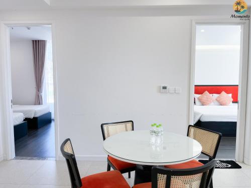 a dining room with a table and chairs and a bedroom at Sunset town Phú Quốc in Phu Quoc