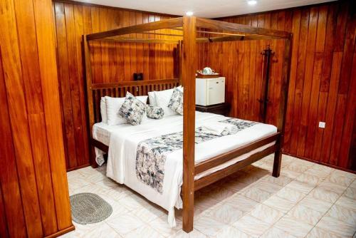 a bedroom with a canopy bed and wooden walls at Cara Galle Fort in Galle