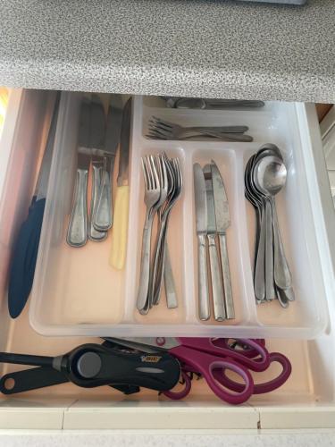 a drawer filled with utensils and a pair of scissors at Small attic apartment close to Lake and Mountains Fussach in Fußach