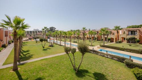 a park with palm trees and a swimming pool at Hotel Prestige Agadir Boutique & SPA in Agadir