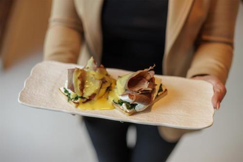 a person is holding a plate of food at Radisson Collection Hotel, Old Mill Belgrade in Belgrade